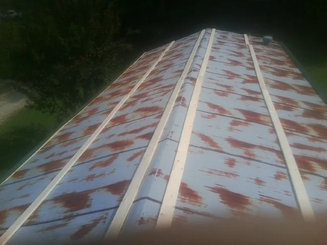 Rusted metal roof panels with new wood purlins before replacement — Storm Damage Roof Repair in Gratis by Roofing Brothers
