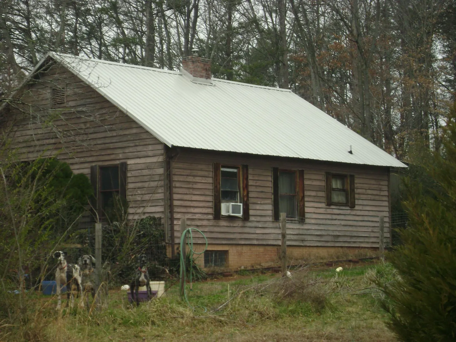 White metal roof on an old wood sided farmhouse, from a Metal Roof Installation job in Gratis